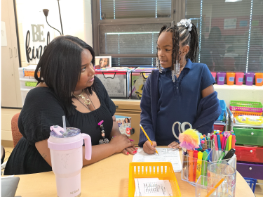 teacher supporting student asking questions on homework